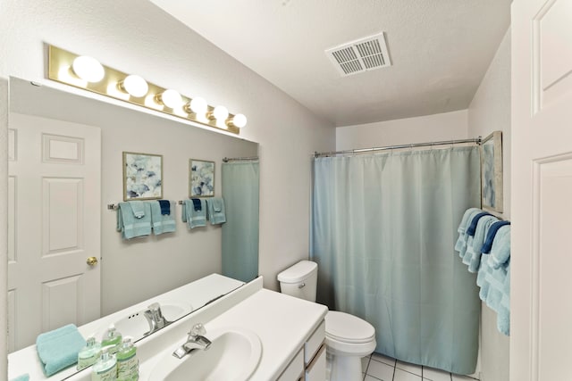 bathroom with vanity, tile patterned flooring, toilet, and a textured ceiling