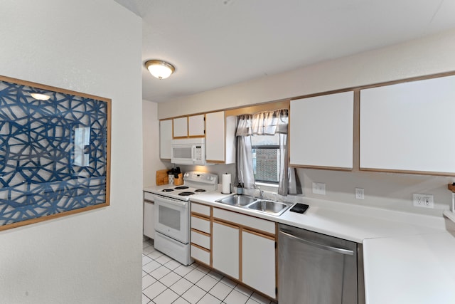 kitchen featuring light tile patterned floors, white cabinets, sink, and white appliances