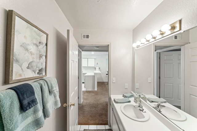 bathroom with tile patterned floors, vanity, and a textured ceiling