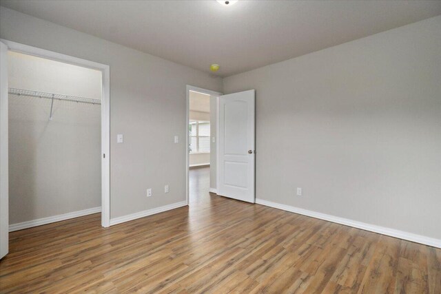 unfurnished bedroom with a closet and light wood-type flooring