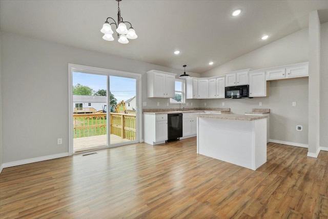 kitchen featuring black appliances, wood-type flooring, hanging light fixtures, white cabinetry, and an inviting chandelier