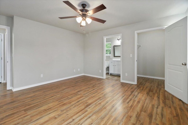 unfurnished bedroom with ceiling fan, light wood-type flooring, and connected bathroom