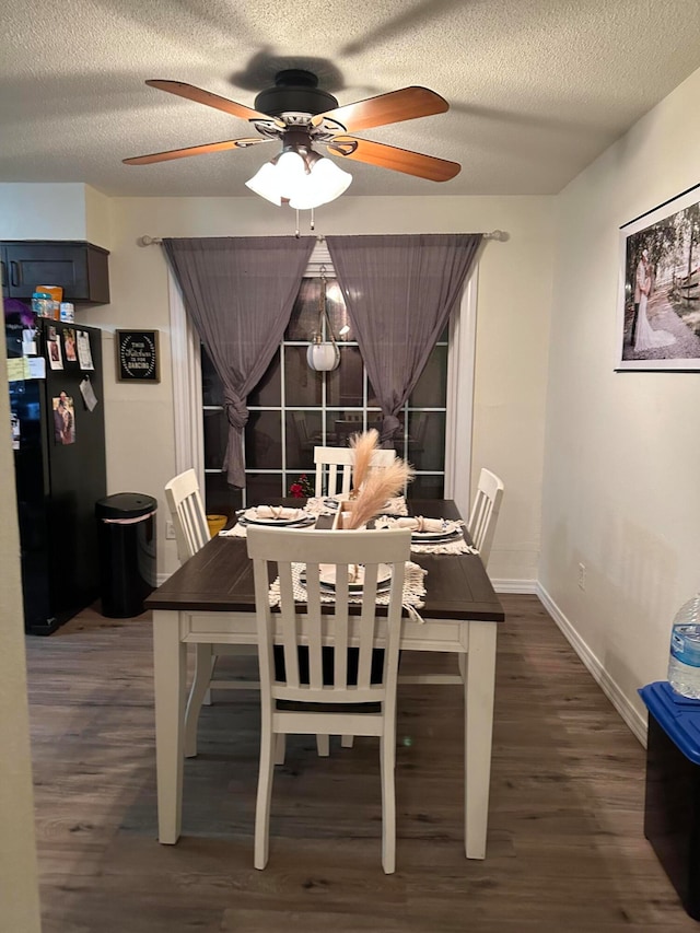 dining space featuring ceiling fan, dark wood-type flooring, and a textured ceiling