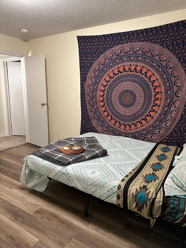 bedroom featuring hardwood / wood-style flooring and a textured ceiling