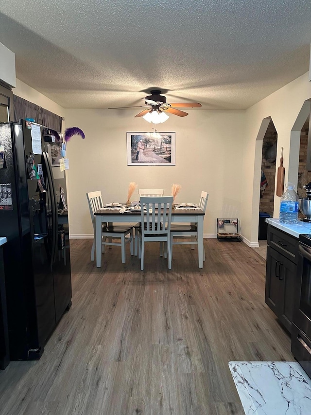 dining room featuring ceiling fan, a textured ceiling, and hardwood / wood-style floors