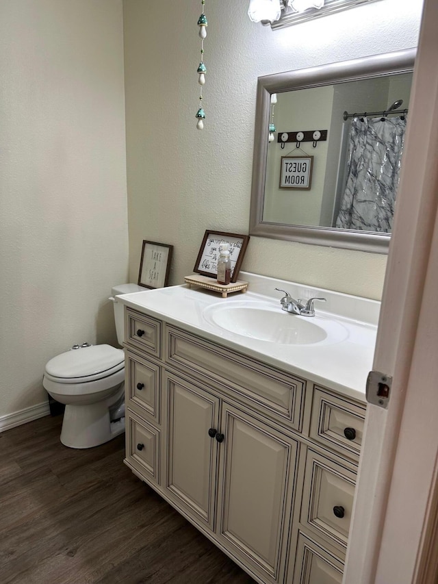 bathroom featuring wood-type flooring, vanity, toilet, and a shower with shower curtain