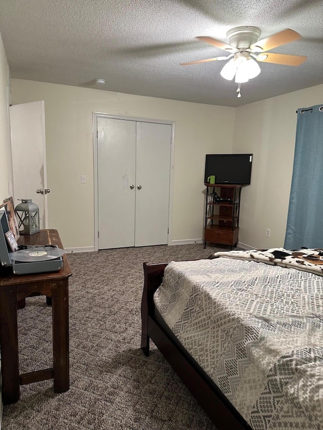 bedroom featuring dark colored carpet, ceiling fan, a closet, and a textured ceiling