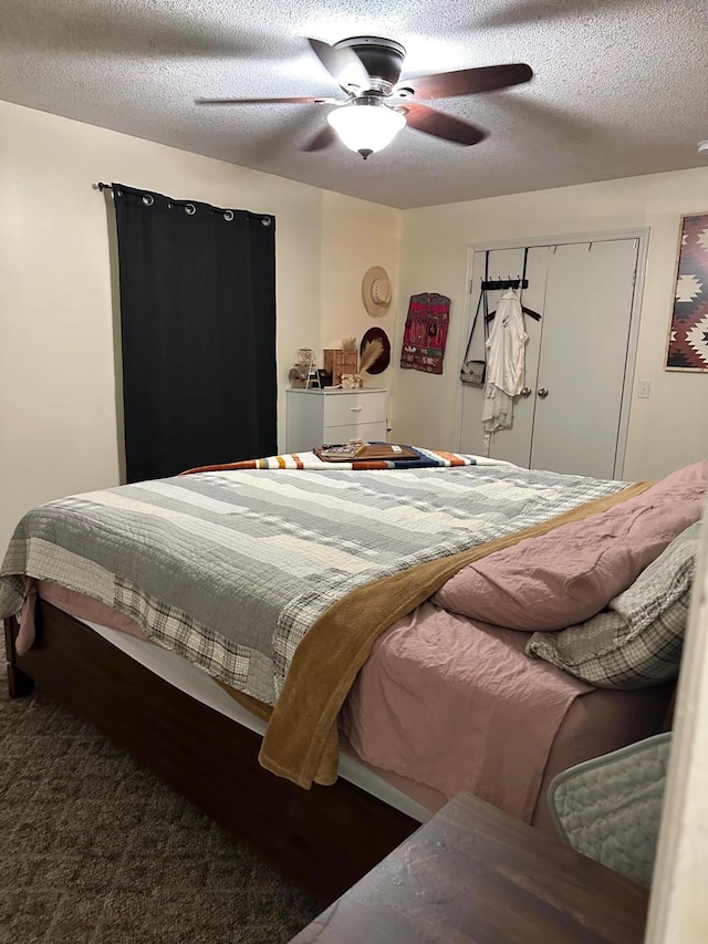 bedroom with ceiling fan, a textured ceiling, and dark carpet