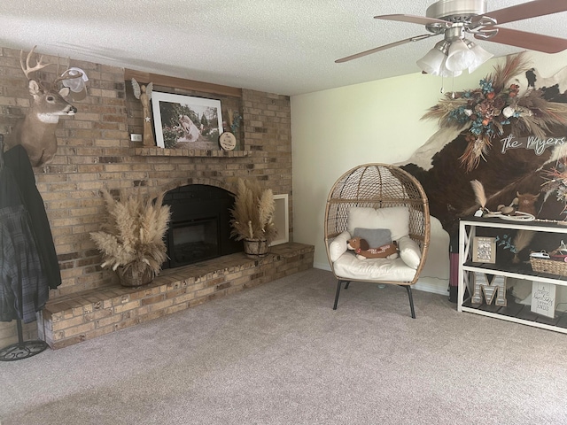 unfurnished room featuring carpet floors, a brick fireplace, ceiling fan, and a textured ceiling