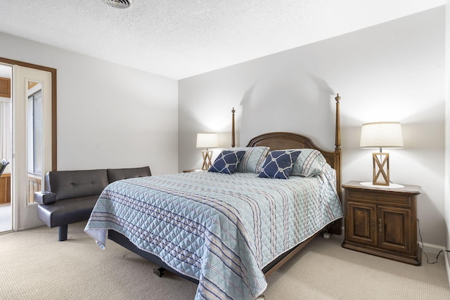 bedroom featuring light colored carpet and a textured ceiling