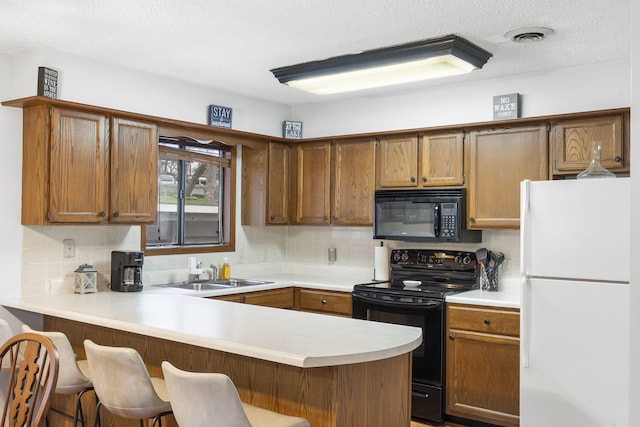3 Port Holiday Dr Unit G, Kimberling City, MO 65686 - kitchen with a sink, black appliances, light countertops, backsplash, and a peninsula