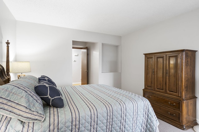 bedroom with a textured ceiling and light colored carpet