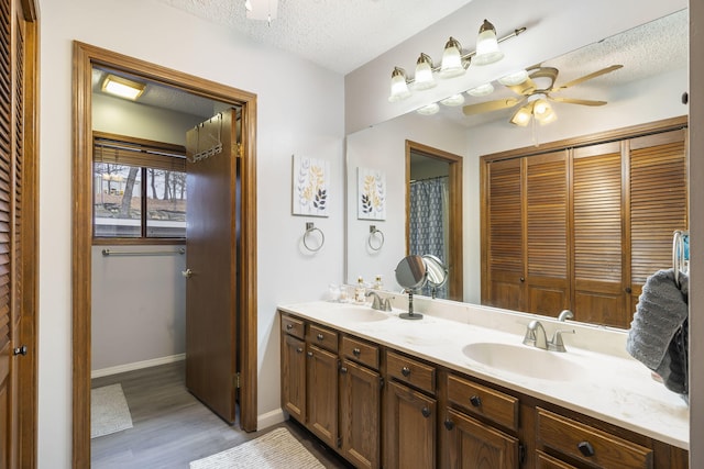 bathroom featuring vanity, a textured ceiling, ceiling fan, and hardwood / wood-style flooring