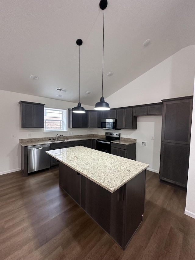 kitchen featuring a center island, sink, vaulted ceiling, decorative light fixtures, and stainless steel appliances