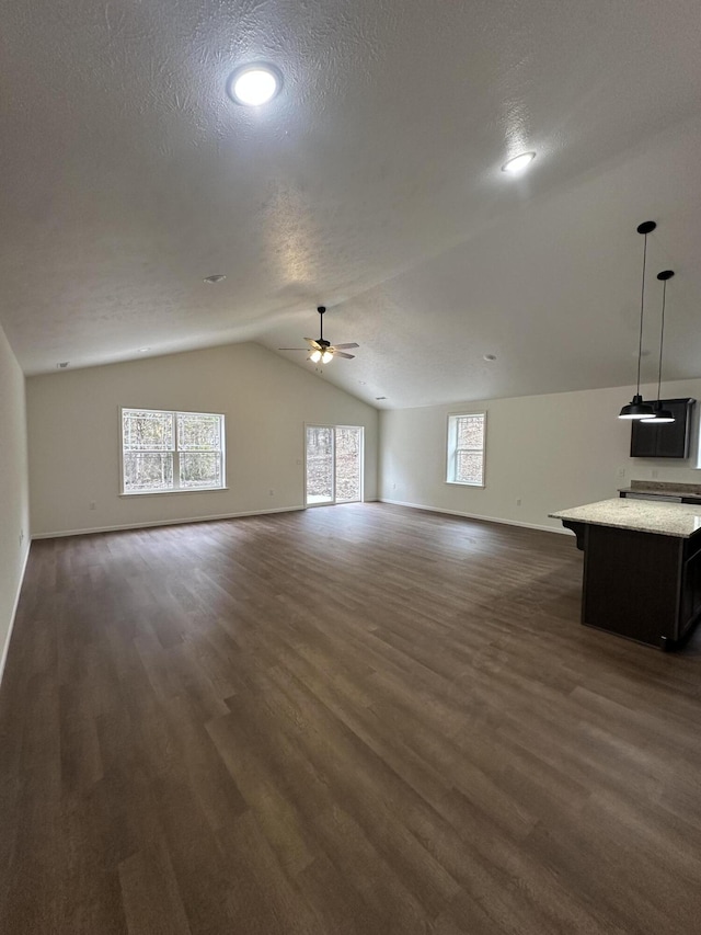 bonus room featuring a textured ceiling, dark hardwood / wood-style floors, vaulted ceiling, and ceiling fan