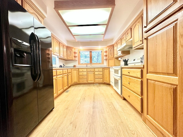 kitchen featuring light brown cabinets, refrigerator with ice dispenser, white range, and light hardwood / wood-style floors