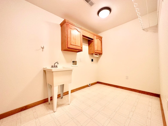 washroom featuring hookup for a washing machine and cabinets