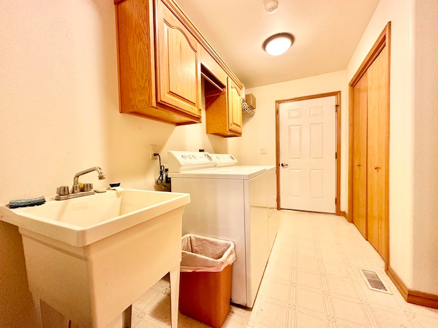 washroom with washing machine and dryer, sink, and cabinets