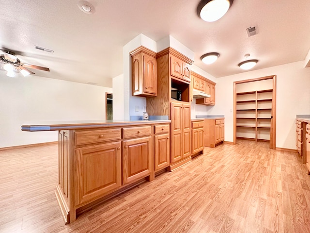 kitchen with a textured ceiling and light hardwood / wood-style floors