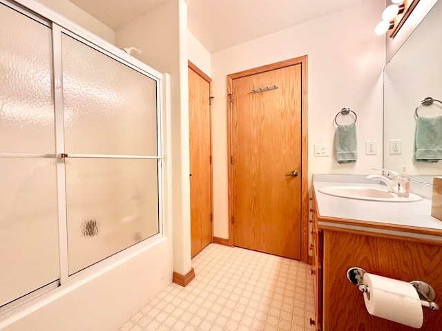 bathroom featuring shower / bath combination with glass door and vanity