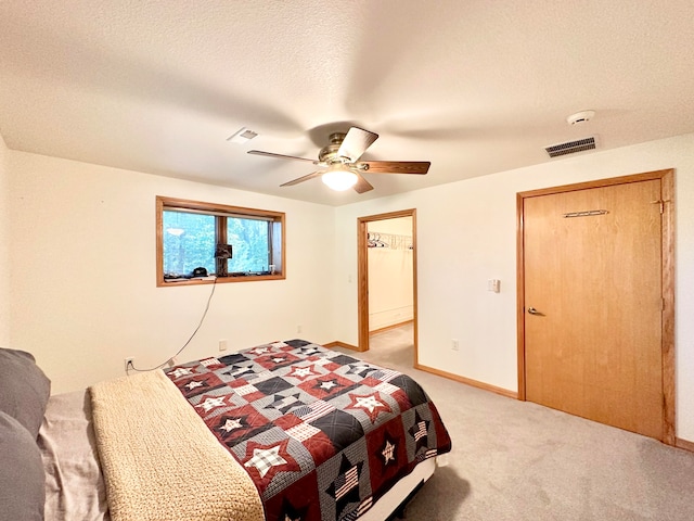 carpeted bedroom featuring a textured ceiling and ceiling fan