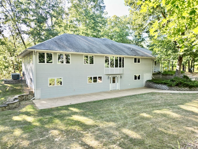 rear view of house featuring a patio, a yard, and central AC unit