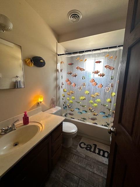 full bathroom featuring shower / bathtub combination with curtain, vanity, and toilet