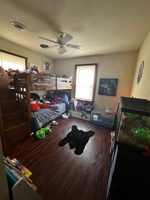 bedroom with dark hardwood / wood-style floors and ceiling fan