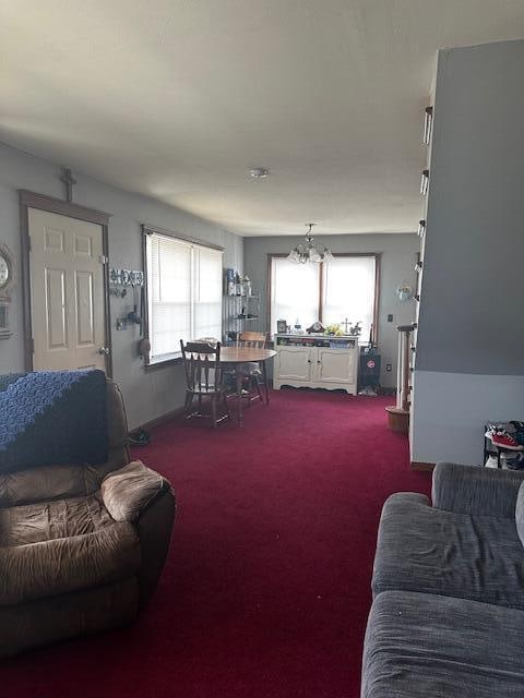 carpeted living room featuring an inviting chandelier