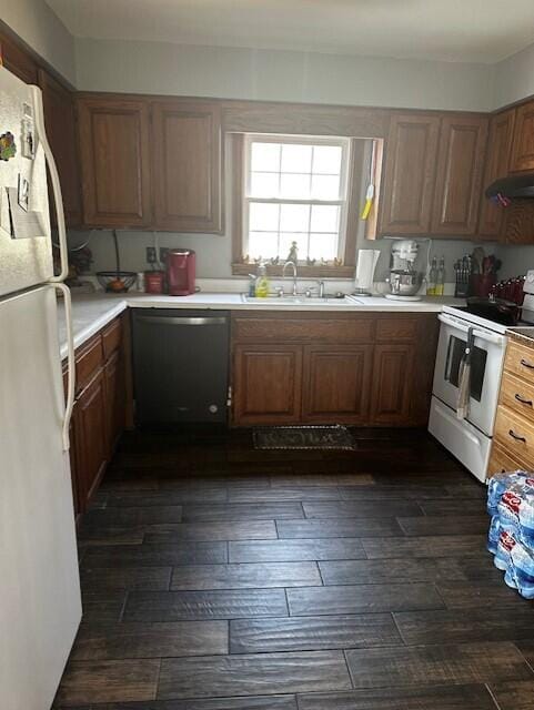 kitchen with extractor fan, white appliances, sink, and dark hardwood / wood-style flooring