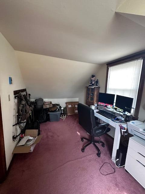 carpeted home office featuring lofted ceiling