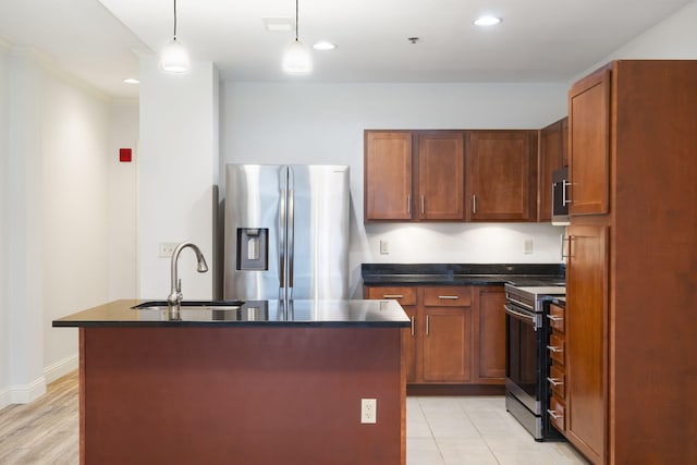 kitchen with stainless steel appliances, sink, light hardwood / wood-style floors, a center island with sink, and decorative light fixtures