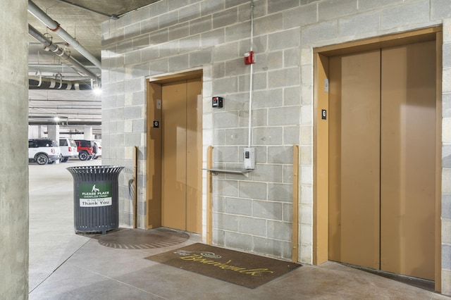 misc room with elevator and concrete flooring