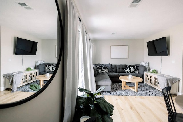 living room featuring baseboards, wood finished floors, and visible vents