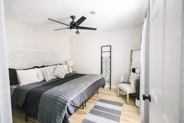 bedroom featuring visible vents, light wood finished floors, and a ceiling fan