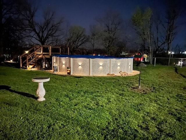 yard at night featuring an empty pool