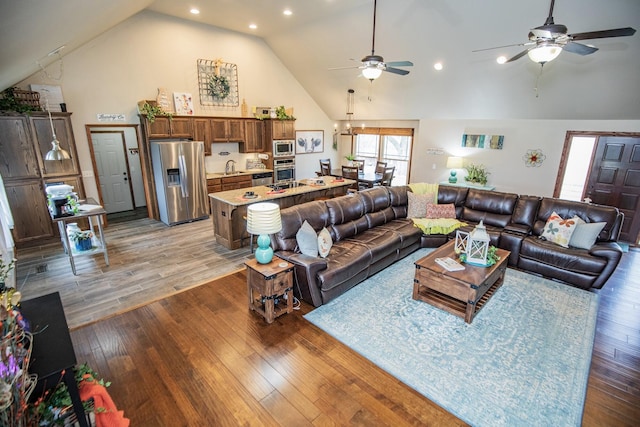 living room featuring ceiling fan, sink, and dark hardwood / wood-style floors