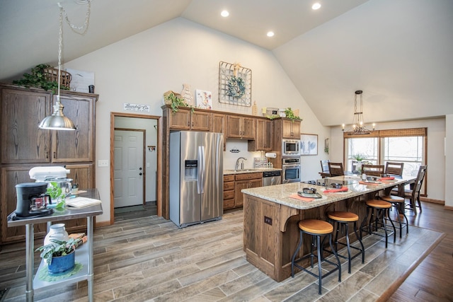 kitchen featuring stainless steel appliances, light hardwood / wood-style floors, a kitchen island, and sink