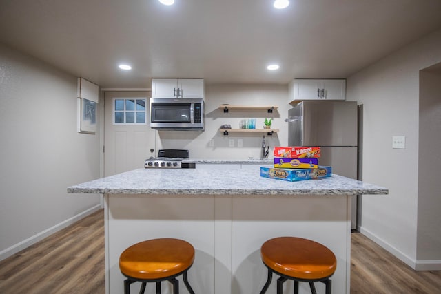 kitchen with white cabinets, stainless steel appliances, and a breakfast bar