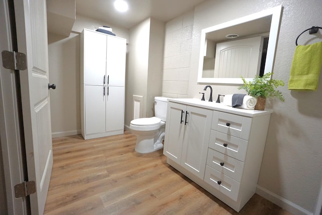 bathroom with vanity, toilet, and hardwood / wood-style flooring