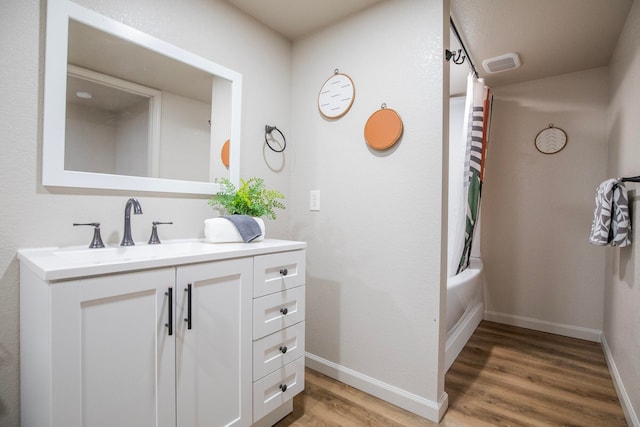 bathroom featuring hardwood / wood-style floors, shower / bath combo, and vanity