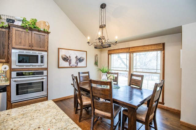 dining space with dark wood-type flooring, high vaulted ceiling, and an inviting chandelier