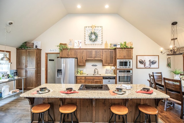 kitchen featuring stainless steel appliances, a breakfast bar area, lofted ceiling, and sink