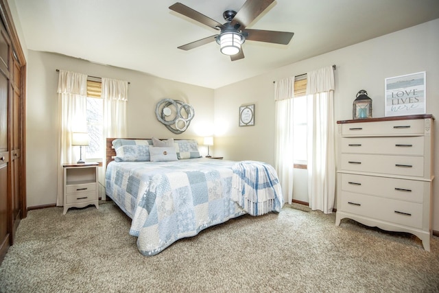 bedroom with ceiling fan, light colored carpet, and a closet