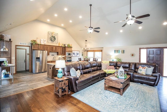 living room with ceiling fan, sink, hardwood / wood-style floors, and high vaulted ceiling