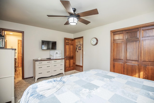 carpeted bedroom with ceiling fan and a closet