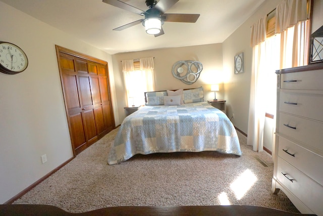 carpeted bedroom featuring ceiling fan and a closet