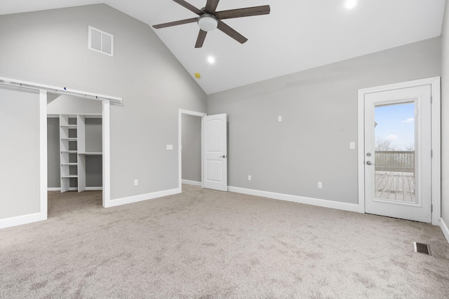 interior space featuring ceiling fan, light colored carpet, high vaulted ceiling, and a walk in closet