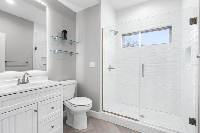 bathroom with vanity, toilet, and a shower with door