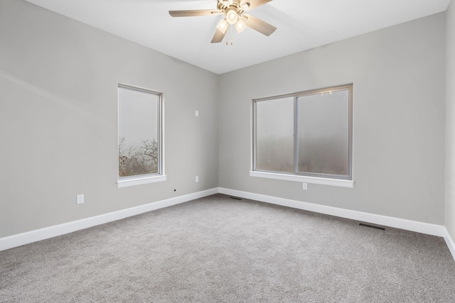 carpeted spare room featuring ceiling fan